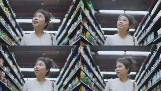 封锁结束了，亚洲女性成年女性享受购物手拉购物车在百货商店的货架上检查消费品高清在线视频素材下载