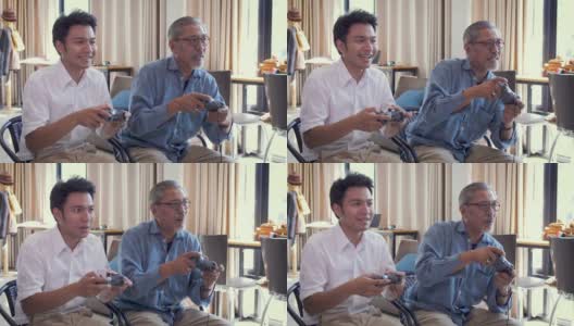 一位亚洲老人和他已成年的儿子一起在家里的客厅里玩电子游戏高清在线视频素材下载