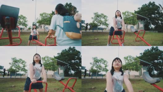 亚洲小女孩正在户外游乐场玩跷跷板高清在线视频素材下载