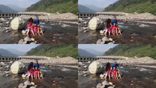 一家人在印度北阿坎德邦瑞诗凯诗的恒河山上玩流水高清在线视频素材下载