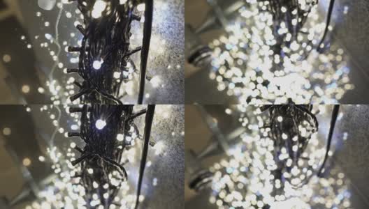 许多发光的LED灯泡在室内。这些是用来做圣诞装饰的。灯泡的电线放在地板上。在看。从上到下倾斜射击。焦点在前面，背景模糊了。高清在线视频素材下载