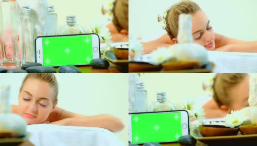 和平的妇女享受aÊ按摩在水疗中心，妇女有治疗按摩在水疗沙龙的背部慢动作与微笑高清在线视频素材下载