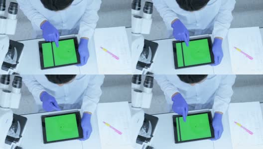 科学家在实验室使用带绿色屏幕的平板电脑高清在线视频素材下载