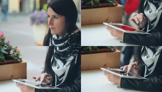 一名年轻女子在街头咖啡馆使用平板电脑高清在线视频素材下载