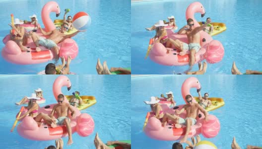 慢镜头:快乐的年轻人在五颜六色的浮子上戏水高清在线视频素材下载