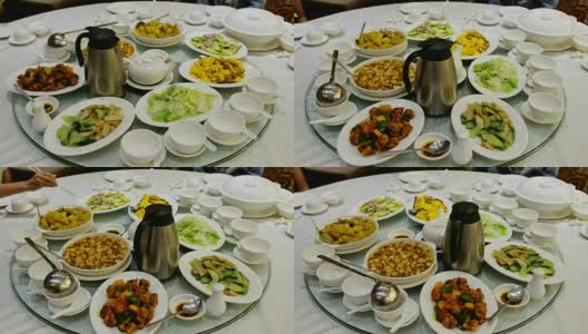 圆形玻璃桌子旋转中国食物，肉类和茶与家人在餐厅高清在线视频素材下载