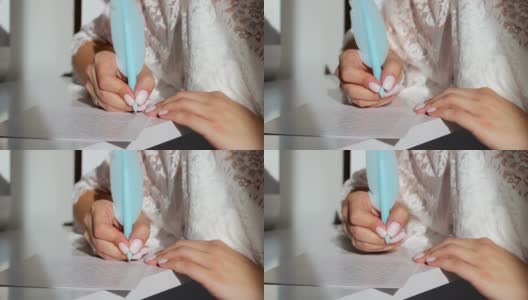 特写的女孩的手拿着一支蓝色的笔，并在笔记本上写。高清在线视频素材下载