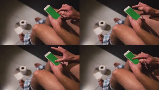 一名穿着裤子的男子手持手机并开始使用手机的视频。上下滑动也可以放大图片。高清在线视频素材下载