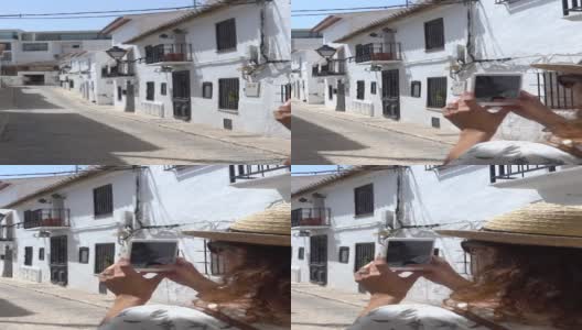 垂直视频的游客卷曲的黑发拍照在白色的村庄Altea，阿利坎特，西班牙高清在线视频素材下载