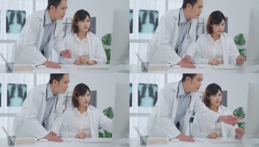 两位医生在医务室的电脑屏幕上分析讨论高清在线视频素材下载