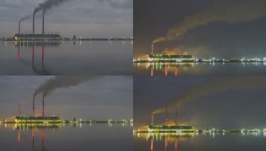 燃煤电厂的高管与黑烟快速移动污染大气在夜间与倒影在湖水。日到夜的时间推移过渡。高清在线视频素材下载