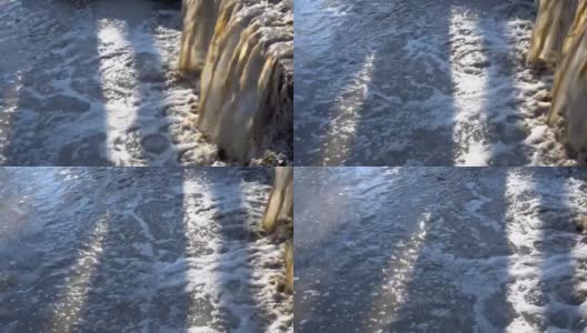 在一个阳光明媚的日子里，肮脏的浑水像瀑布一样从下水道流入河里。特写镜头。环境污染的概念。4 k。高清在线视频素材下载