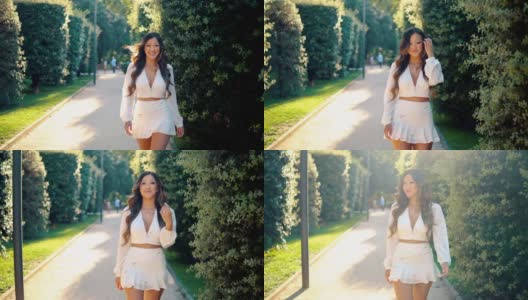 美丽的亚洲女孩穿着白色的裙子在公园微笑高清在线视频素材下载