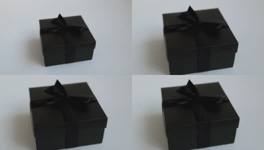 节日礼物在黑色美丽的盒子在白色的背景。优雅的黑色节日盒与缎带。高清在线视频素材下载