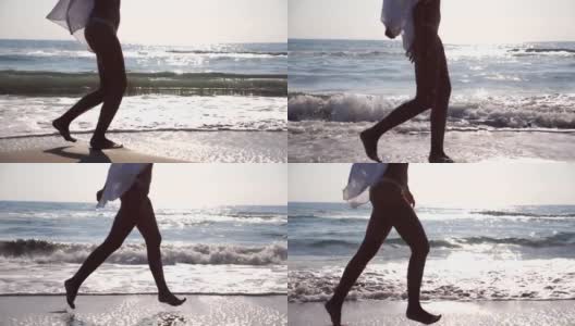 日出时，穿着比基尼和衬衫的陌生女人的脚在海浪上奔跑。年轻美丽的女孩慢跑和在海边玩。暑假或假日概念。关闭侧视图慢动作高清在线视频素材下载