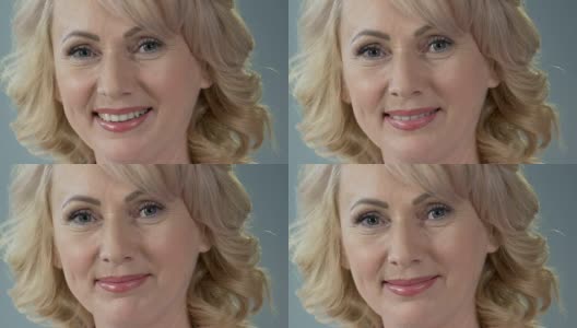迷人的退休女性微笑着看着镜头，抗老化的化妆高清在线视频素材下载