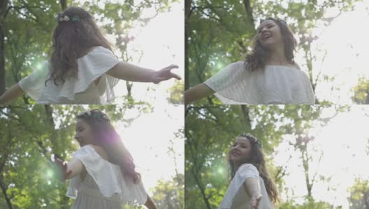 微笑的美丽女孩在森林中慢镜头旋转高清在线视频素材下载