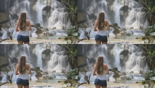 慢镜头女孩站在琅勃拉邦欣赏惊人的瀑布，老挝高清在线视频素材下载