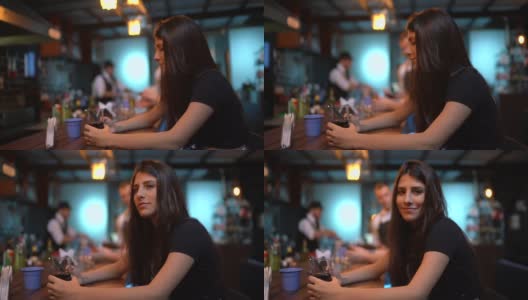 一名年轻女子在酒吧使用智能手机的肖像高清在线视频素材下载