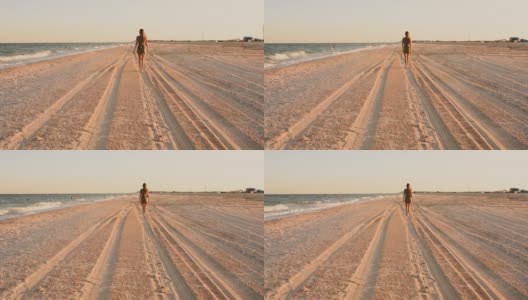 女人走在海滩沿着海滨丁字裤比基尼内裤赤裸的booty高清在线视频素材下载