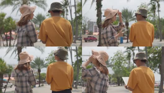 愉快的亚洲年轻夫妇游客拉着他们的手漫步在城市中。高清在线视频素材下载