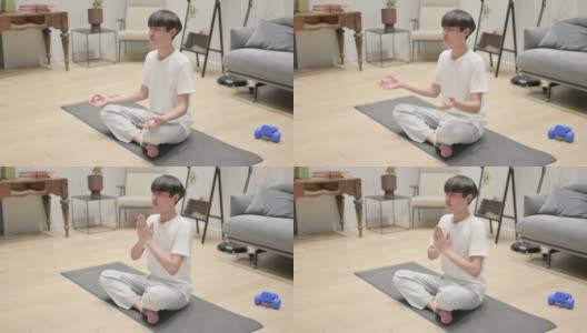 年轻的亚洲男子在家冥想瑜伽垫高清在线视频素材下载