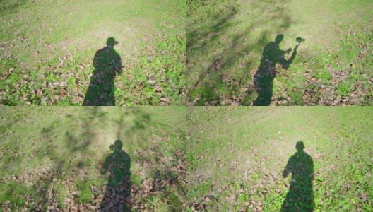摄像师的影子在草地上跟着人移动高清在线视频素材下载