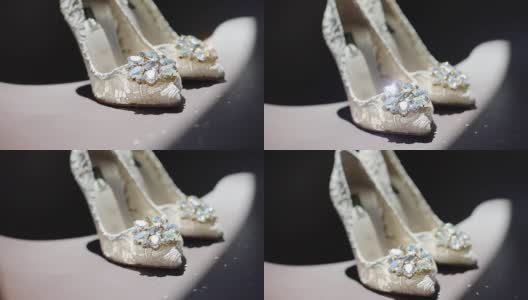 女性白色蕾丝设计鞋与闪亮的钻石站近室内在黑暗的背景文字。婚礼豪华鞋与宝石架焦点闪亮在地板上。新娘时装设计师高清在线视频素材下载