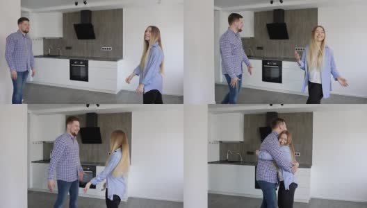 一对年轻男女享受着他们的新公寓，微笑着在厨房里拥抱着彼此高清在线视频素材下载