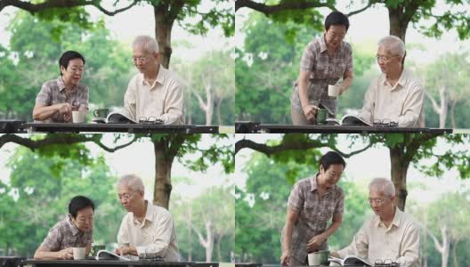 亚洲老年夫妇在美丽的公园早上喝咖啡高清在线视频素材下载