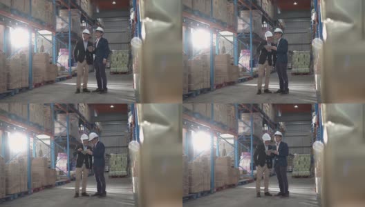 亚洲华人管理人员在仓库用数码平板电脑与白帽公司讨论高清在线视频素材下载