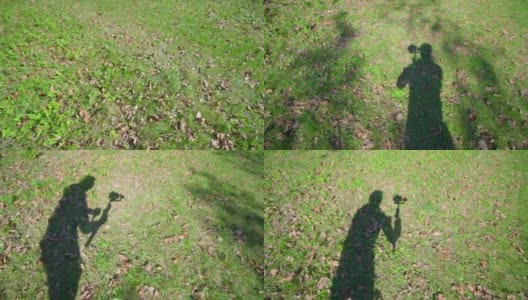 操作者移动摄像机拍摄草地的影子高清在线视频素材下载