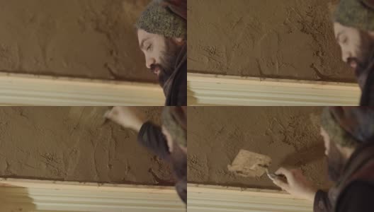一个新手把粘土涂在他房子的墙上，自己动手高清在线视频素材下载