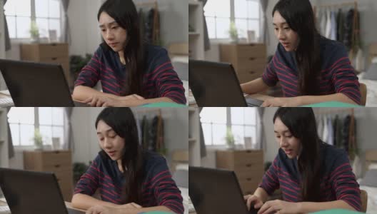 焦急的亚洲女学生用手指敲着桌子，在家里用电脑学习的过程中，想到了解决问题的好办法，露出了笑容高清在线视频素材下载