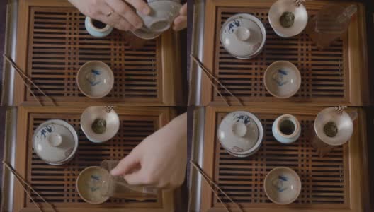 师傅将茶水从白杯倒入茶碗中。中国茶道高清在线视频素材下载