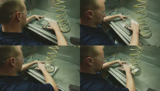 一名白种技术人员使用电动砂光机对生产设备中的铝制零件进行抛光和去毛刺高清在线视频素材下载