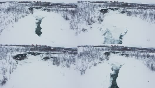 在瑞典北部阿比斯科的一个阴天，无人机拍摄的峡谷与冰冻的河流高清在线视频素材下载
