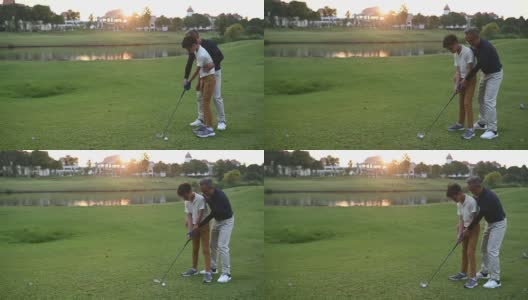 日落时分，一位亚洲华人老人在高尔夫球场上教孙子如何打高尔夫高清在线视频素材下载