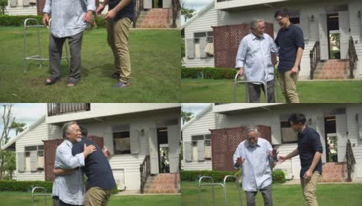 亚洲老人带着沃克和成年的儿子一起走在加登的家里。老人残疾行走和照顾年轻人帮助在后院。保健家庭生活方式高清在线视频素材下载