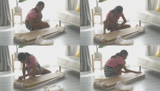 亚洲女孩使用切割机打开棕色盒子，这是从网上购物买的一些家具，生活方式的概念。高清在线视频素材下载
