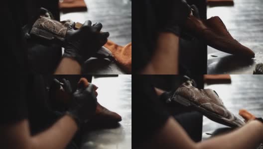鞋匠用刷子和泡沫清洁旧浅棕色皮鞋的跟踪镜头，特写。高清在线视频素材下载