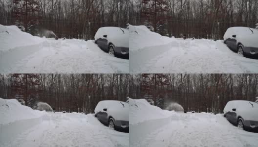 一名男子在一场暴风雪后用除雪机清理被雪覆盖的车道。高清在线视频素材下载