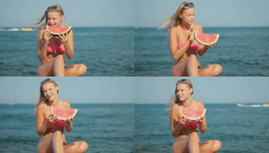 迷人的金发女人在海滩上吃西瓜高清在线视频素材下载