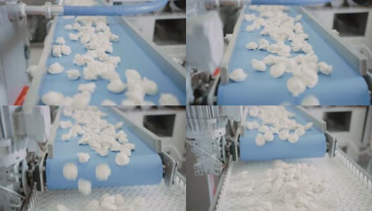 在饺子工厂的自动机器生产过程的近距离镜头。新鲜生Pelmeni落在传送带上。在食品工厂操作的工业机械。高清在线视频素材下载