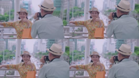 一位老人在阳台上与粉丝们合影，以泰国首都为背景。高清在线视频素材下载