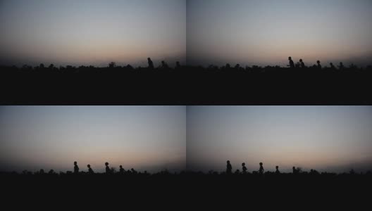 日落时分，在稻田中奔跑玩耍的孩子们的剪影高清在线视频素材下载