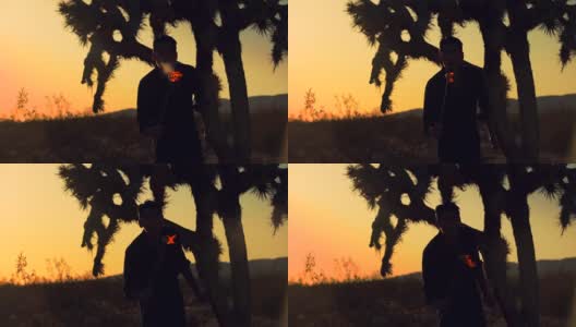 日落时分，沙漠中一个人吹着火前进的剪影高清在线视频素材下载