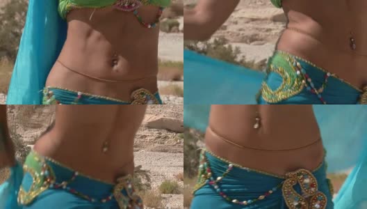 漂亮的女舞者。肚皮舞。沙漠。性感的绿蓝裙舞高清在线视频素材下载