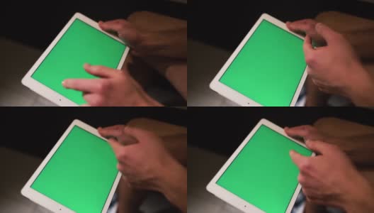 拍摄过程视频，人拿着平板电脑，向右滑动。绿色的屏幕。坐在厕所或休息室里的家伙。高清在线视频素材下载