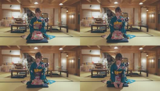 穿着Furisode和服的年轻女子坐在高跟鞋上，在日本的榻榻米房间鞠躬高清在线视频素材下载